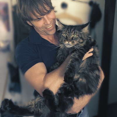 man holding a full grown maine coon cat