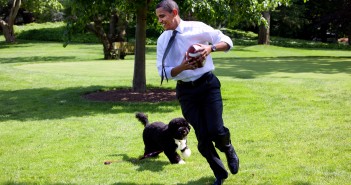 President Barack Obama, with the family dog Bo, playing football on the South Lawn of the White House May 12, 2009.