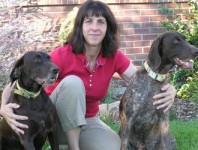 Dr. Cheryl Aguiar sitting beside her two dogs.