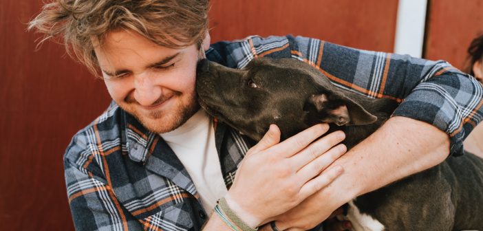 man and his dog showing affection