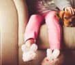 little girl and her dog sitting together on a couch