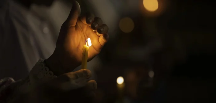 close up of a hand-held candle at a candlelight vigil