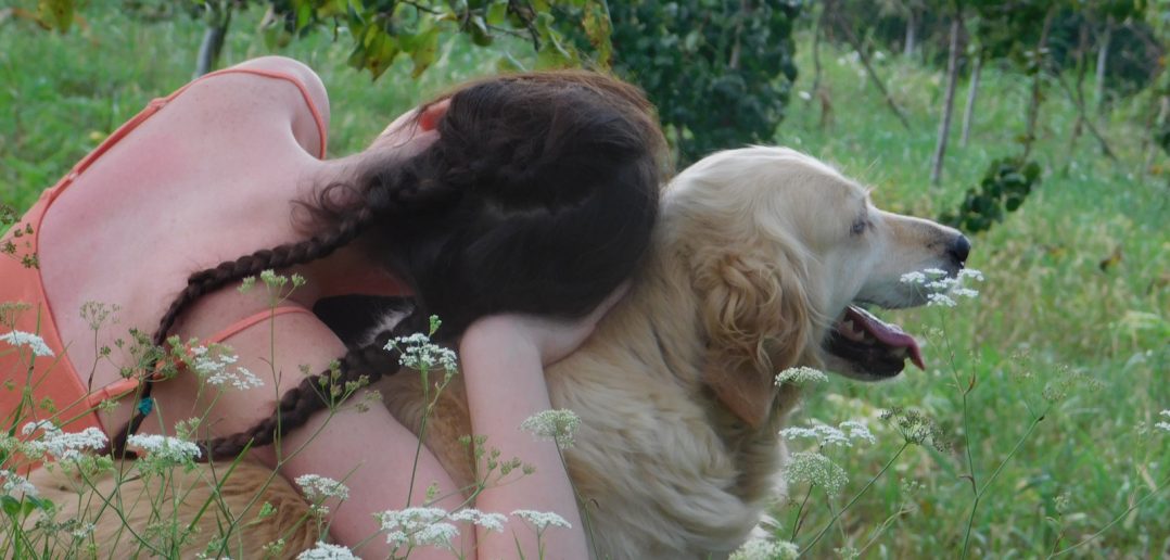 a girl and her dog sitting outside