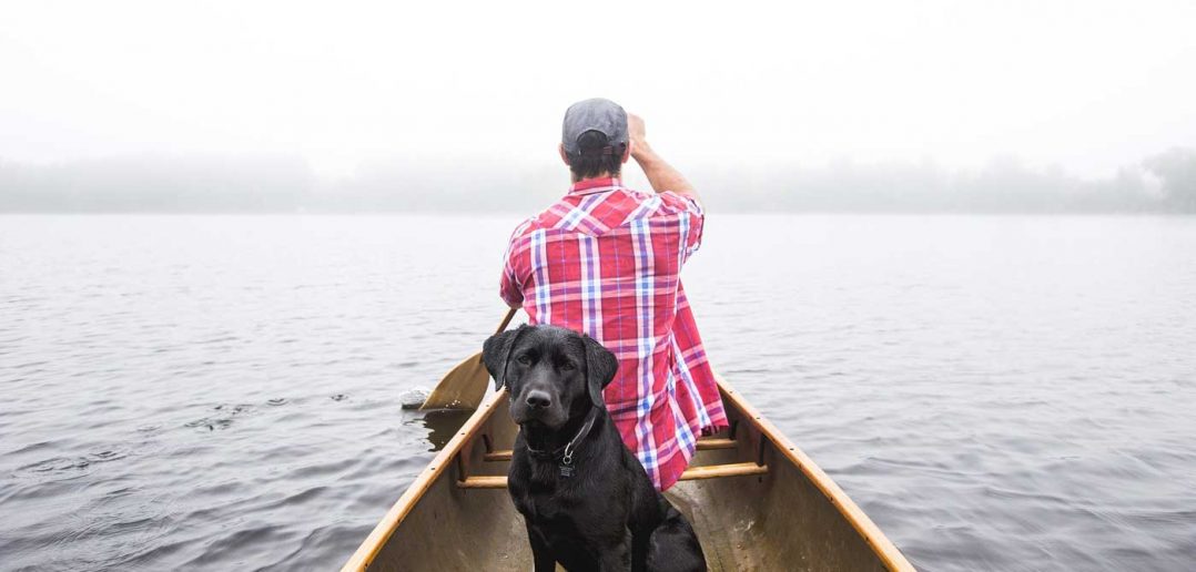 man and dog in a boat