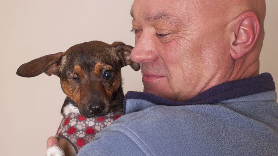 man holding his one-eyed puppy