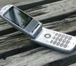 mobile flip phone sitting open on a picnic table