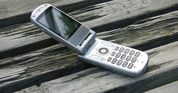 mobile flip phone sitting open on a picnic table